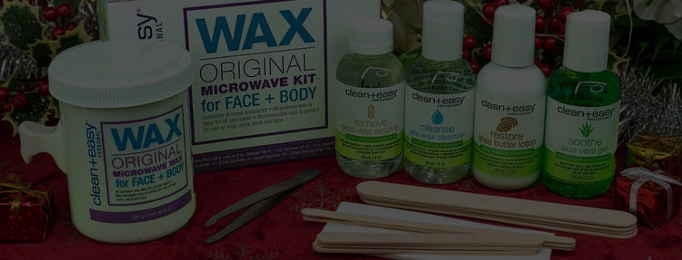 Wax kit for face and body with bottles and tools on a red surface with festive background.